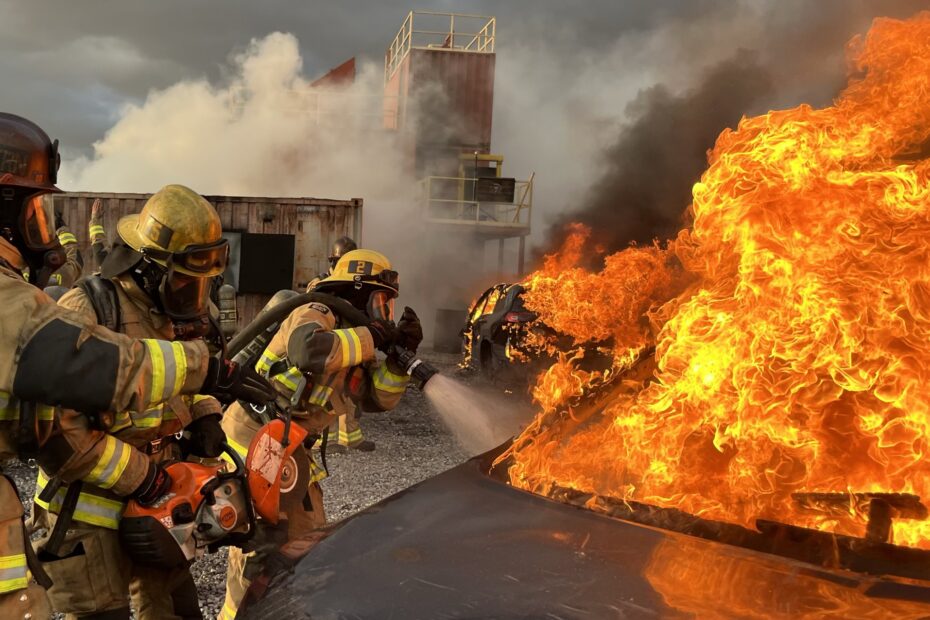 firefighters using extinguisher on car fire